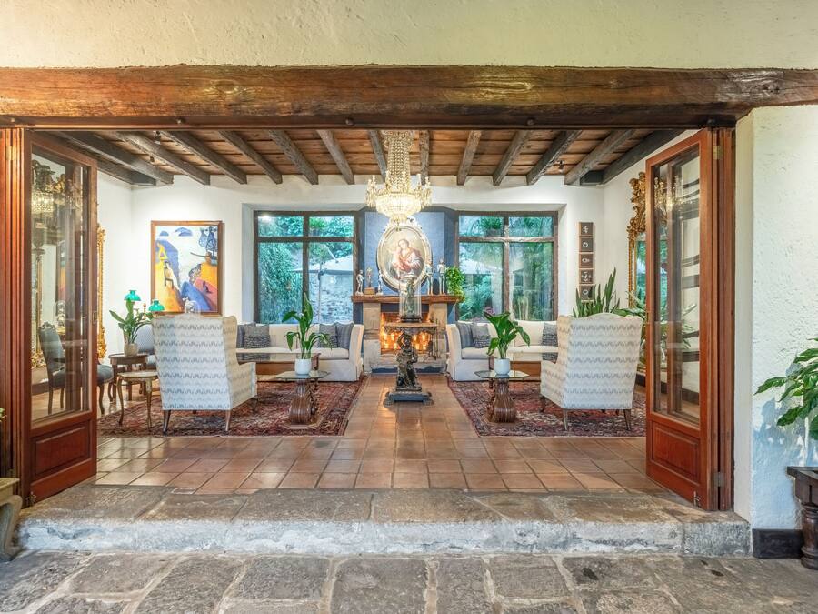 A cozy living room with a fireplace, comfortable seating, and a view of the outdoors.