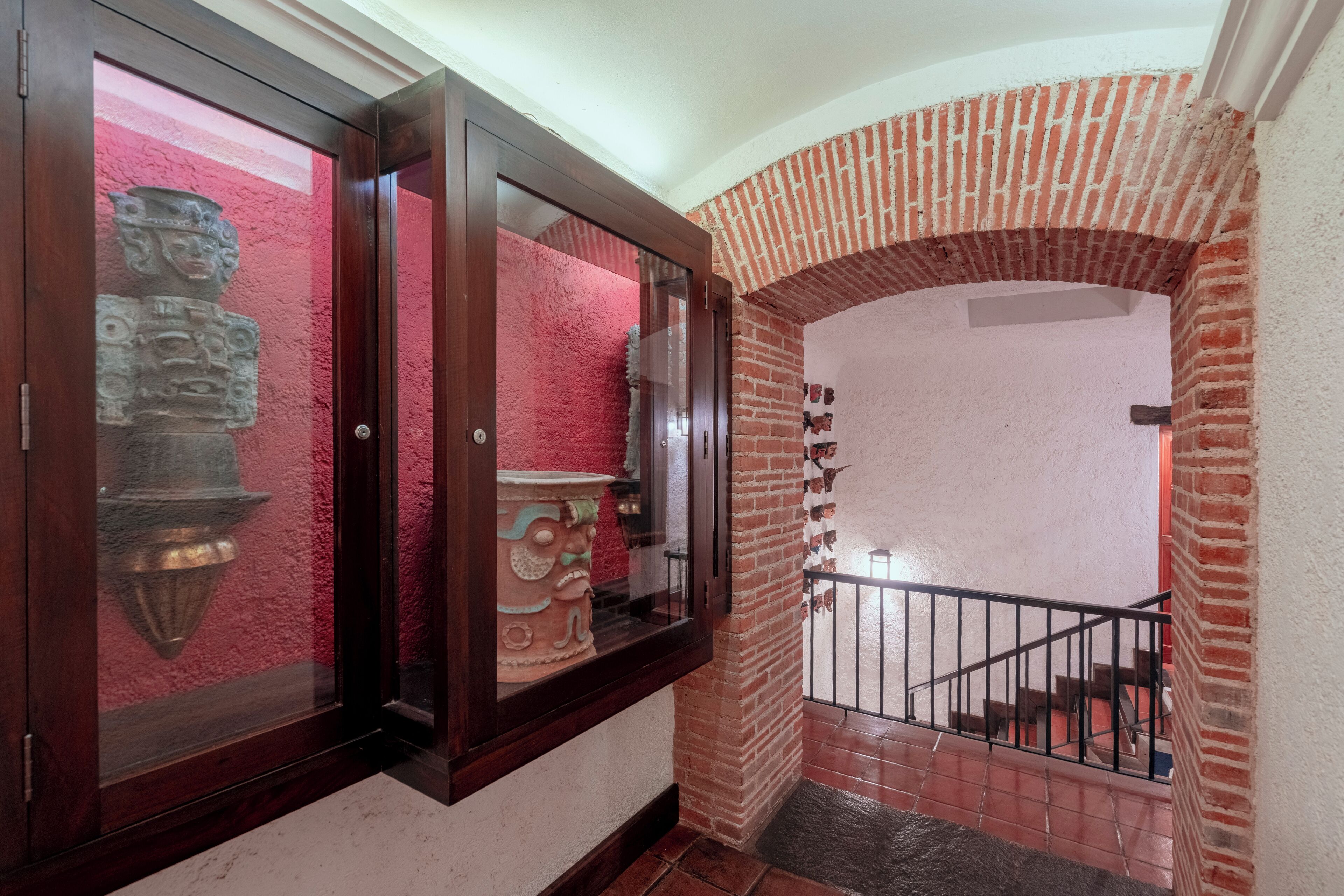 Una escalera con un arco de ladrillo y barandilla de madera.