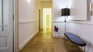 A hallway with a bench, a lamp, and a potted plant. - Hold Rome (Rome)