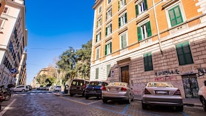 A street with parked cars and buildings with green shutters. - Hold Rome (Rome)