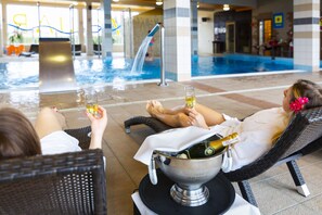 A poolside area with lounge chairs, a champagne bottle, and a glass of champagne. - Hotel Victoria (Wejherowo)