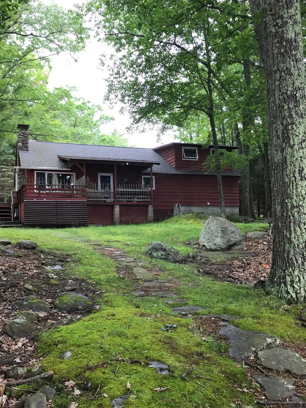 A rustic cabin with a porch, surrounded by a natural landscape with rocks and moss. - Vintage 1950's Lakefront Cabin  Private Dock, Sunrise Views & Pet Friendly (Lakeville)