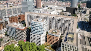 A high-rise building with multiple floors, large windows, and a modern architectural design. - Nemea Appart Hotel So Cloud Lyon Part Dieu (Lyon)