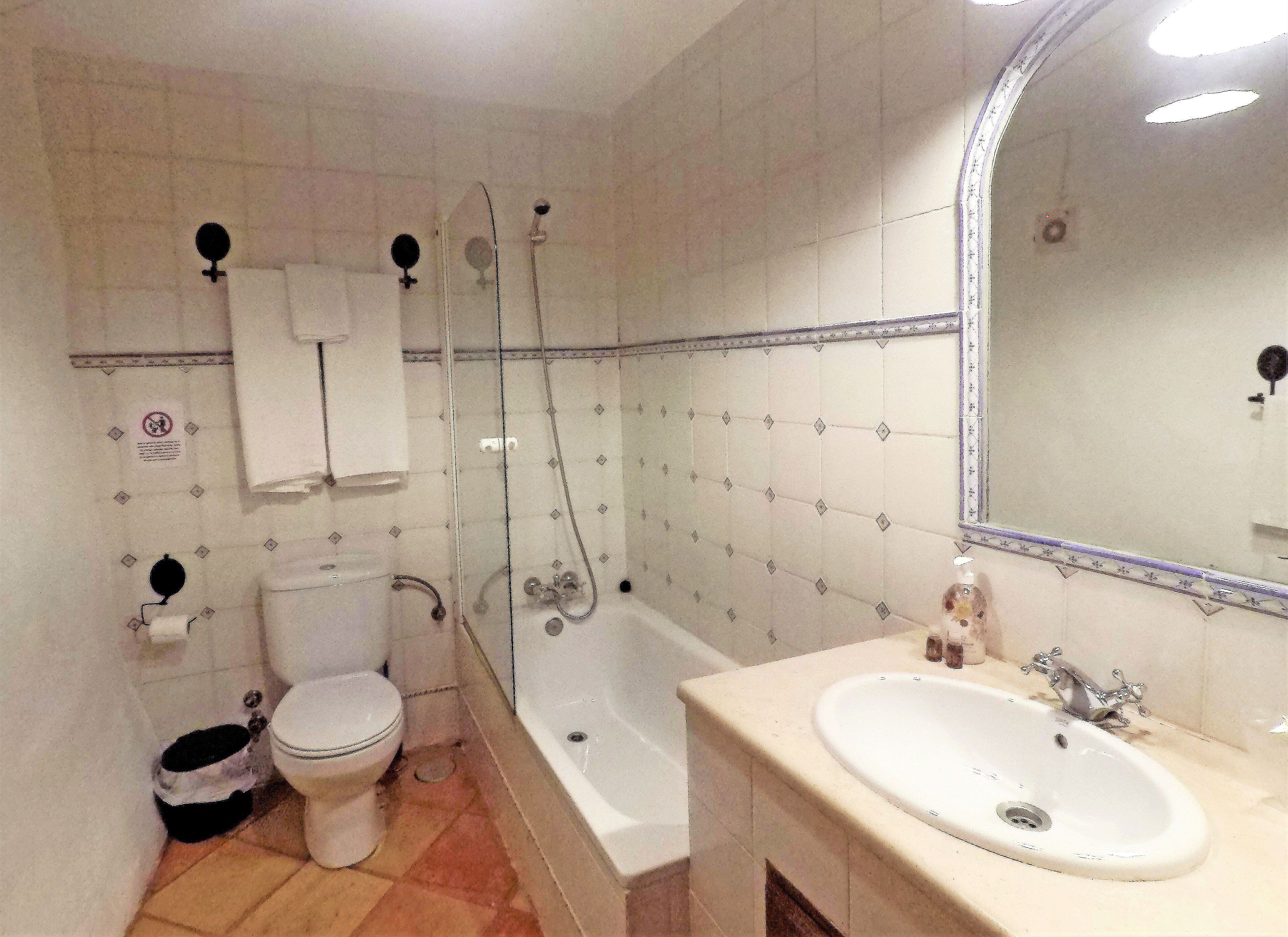 Un baño con inodoro, bañera y lavamanos.