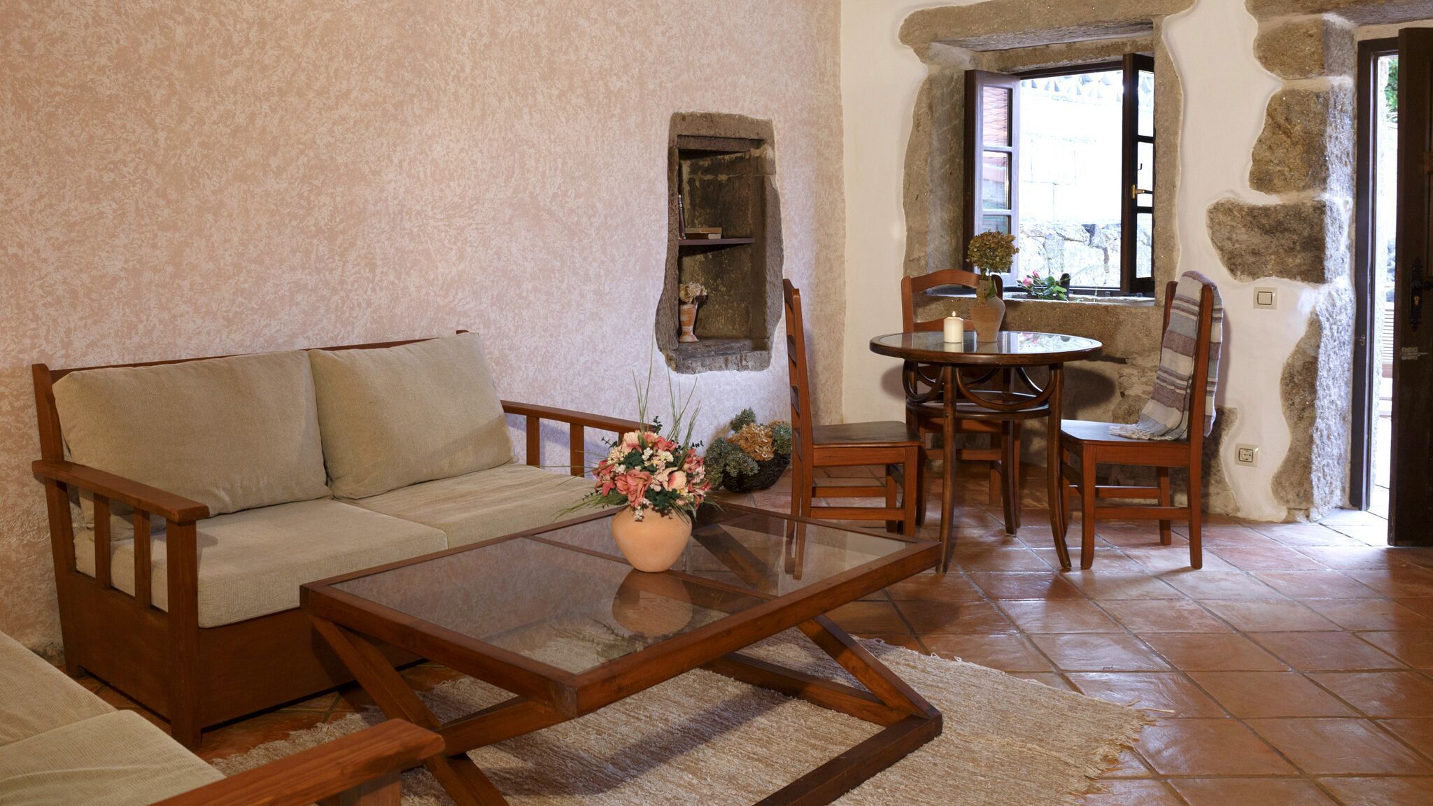 A cozy living room with a sofa, a coffee table, and a dining area with chairs and a small table.