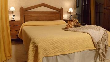 A bed with a wooden headboard, two bedside lamps, a yellow blanket, and a decorative item on the bed.