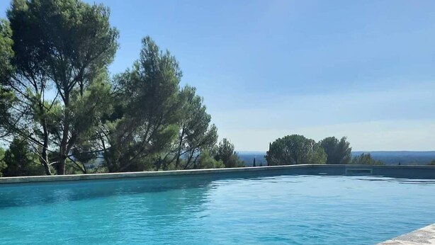 A poolside view with a plate of watermelon and grapes, and a plate of melon and grapes. - Exceptional view 4 km from l'isle/sorgue (Velleron)