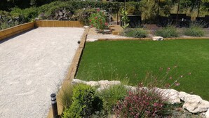 A well-maintained garden with a gravel area, a green lawn, and various plants and rocks. - Exceptional view 4 km from l'isle/sorgue (Velleron)