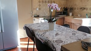 A kitchen with a tiled backsplash, a clock, and a potted orchid on the counter. - Exceptional view 4 km from l'isle/sorgue (Velleron)