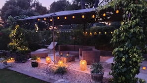 An outdoor patio area with wicker furniture, string lights, and potted plants. - Exceptional view 4 km from l'isle/sorgue (Velleron)
