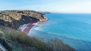 A coastal landscape with a beach, rocky cliffs, and a clear blue sky. - 1 bedroom accommodation in Torquay (Torquay)