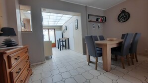 A dining area with hexagonal patterned flooring, a wooden table, and blue chairs.