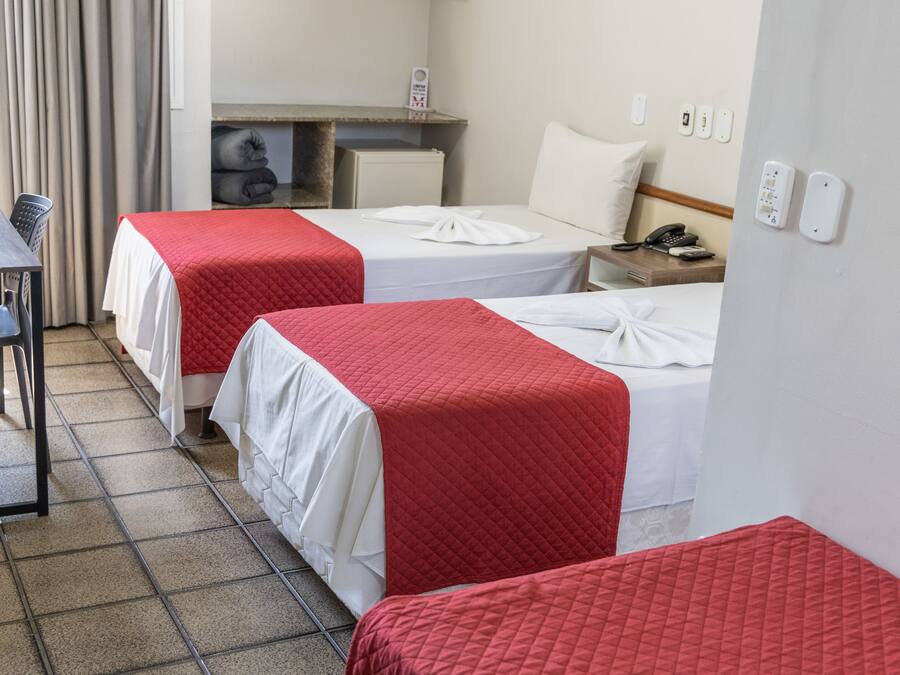 Hotellihuone, jossa on kaksi sänkyä, työpöytä ja tuoli.