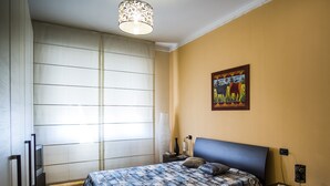 A bedroom with a bed, bedside table, lamp, and a painting on the wall. - VIOLINS AND MUSIC APARTMENT IN DOWNTOWN CREMONA - AT ANTONELLA'S HOUSE - (Cremona)