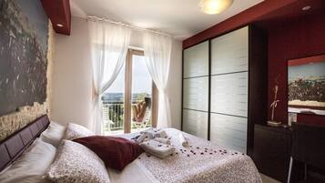 Una camera da letto con un letto, una scrivania, una sedia, una finestra con tende e vista sull'esterno.