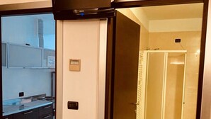 Una cocina moderna con armarios oscuros y un televisor integrado.