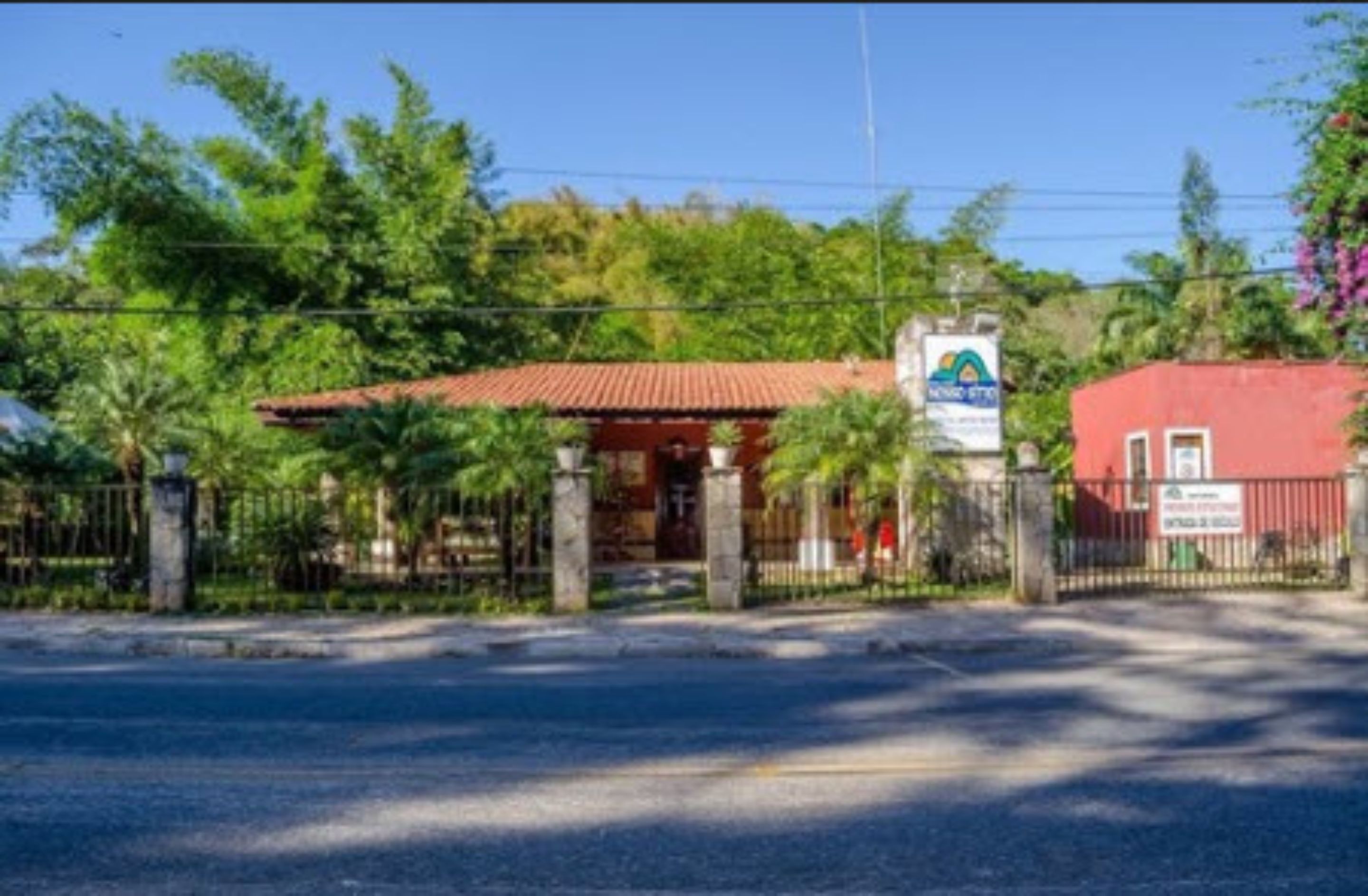 A building with a red roof and a sign indicating it is a hotel.