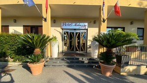 Hotel Milazzo with a signboard, entrance, and potted plants.