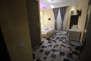 A hotel room with a bed, a desk, and a chair. - Quest House Lihong (Rome)