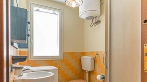 Ein kleines Badezimmer mit Toilette, Bidet und Waschbecken.