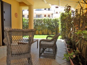 A covered patio area with wicker furniture and potted plants. - Casa Lauro (Ragusa)