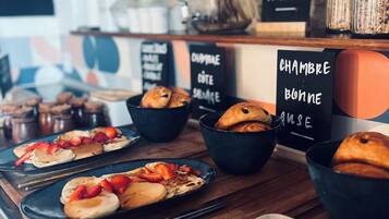 A breakfast buffet with various pastries and fruits.