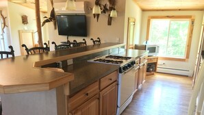 A kitchen with wooden cabinets, a stove, and a large island.