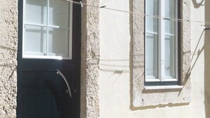 A building with a dark entrance door and a window with white frames. - NEW HOUSE DESIGN, TYPICALISBON (Lisboa)