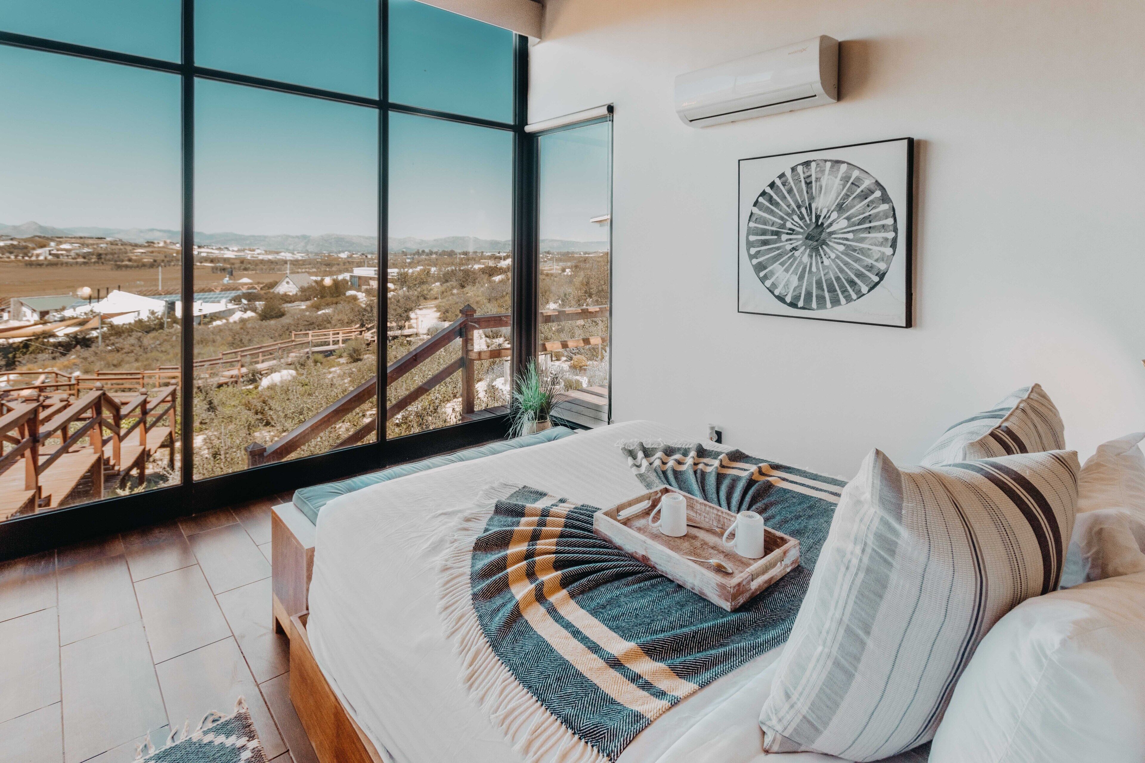 Un dormitorio con un ventanal que ofrece vistas a un paisaje.