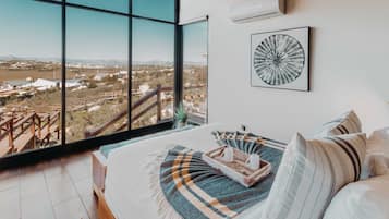 Un dormitorio con un ventanal que ofrece vistas a un paisaje.