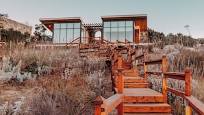 A wooden staircase leading to a modern building with large windows. - Contemplacion Resort & Spa (Valle de Guadalupe)