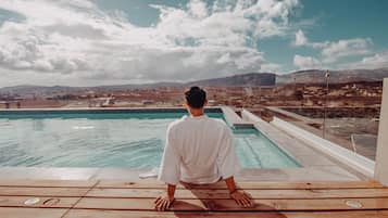 Una piscina al aire libre, sillones reclinables de piscina