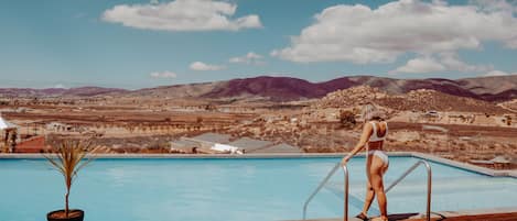 Una piscina al aire libre, sillones reclinables de piscina