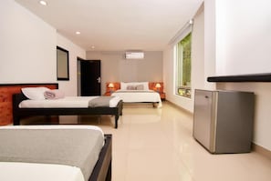 A hotel room with two beds, a refrigerator, and a window with a view. - Tik by Bernalo Hotels (Medellín)