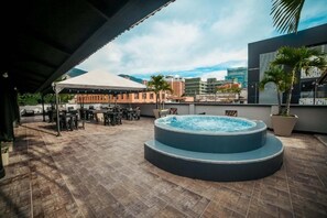 A rooftop terrace with a hot tub, outdoor seating, and a view of the cityscape. - Tik by Bernalo Hotels (Medellín)