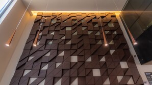 A modern interior with geometric wall panels and pendant lighting. - Hotel Highland Chihuahua (Chihuahua)