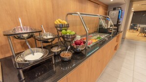 A buffet area with various food options including fruits, yogurt, and cereal. - Hotel Highland Chihuahua (Chihuahua)