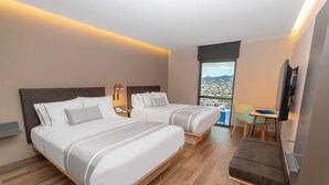 A hotel room with two beds, a desk, a chair, a TV, and a balcony with a city view. - Hotel Highland Chihuahua (Chihuahua)