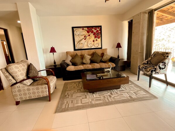 A living room with a sofa, two armchairs, a coffee table, and a painting on the wall. - DREAM BAY AND BEACH VIEWS FROM CONDO B3 AT VILLAS ALTAS MISMALOYA (Mismaloya)