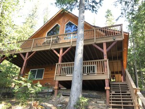 A wooden cabin with a balcony and a staircase leading to an upper level. - —Priest Lake Waterfront Escape— (Coolin)
