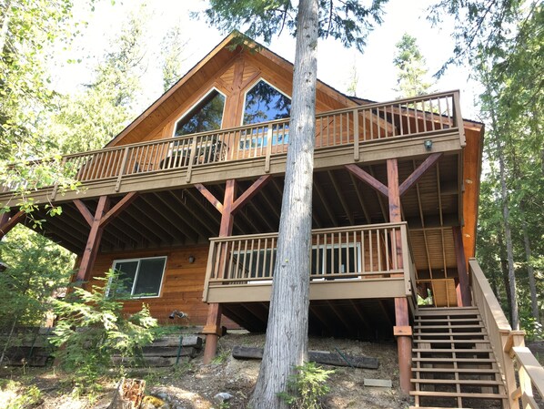 A wooden cabin with a balcony and a staircase leading to an upper level. - —Priest Lake Waterfront Escape— (Coolin)