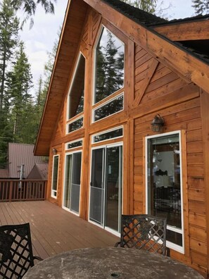 A wooden cabin with large windows and a deck. - —Priest Lake Waterfront Escape— (Coolin)