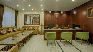 Zona de recepción con mostrador, un sofá y tres sillones.