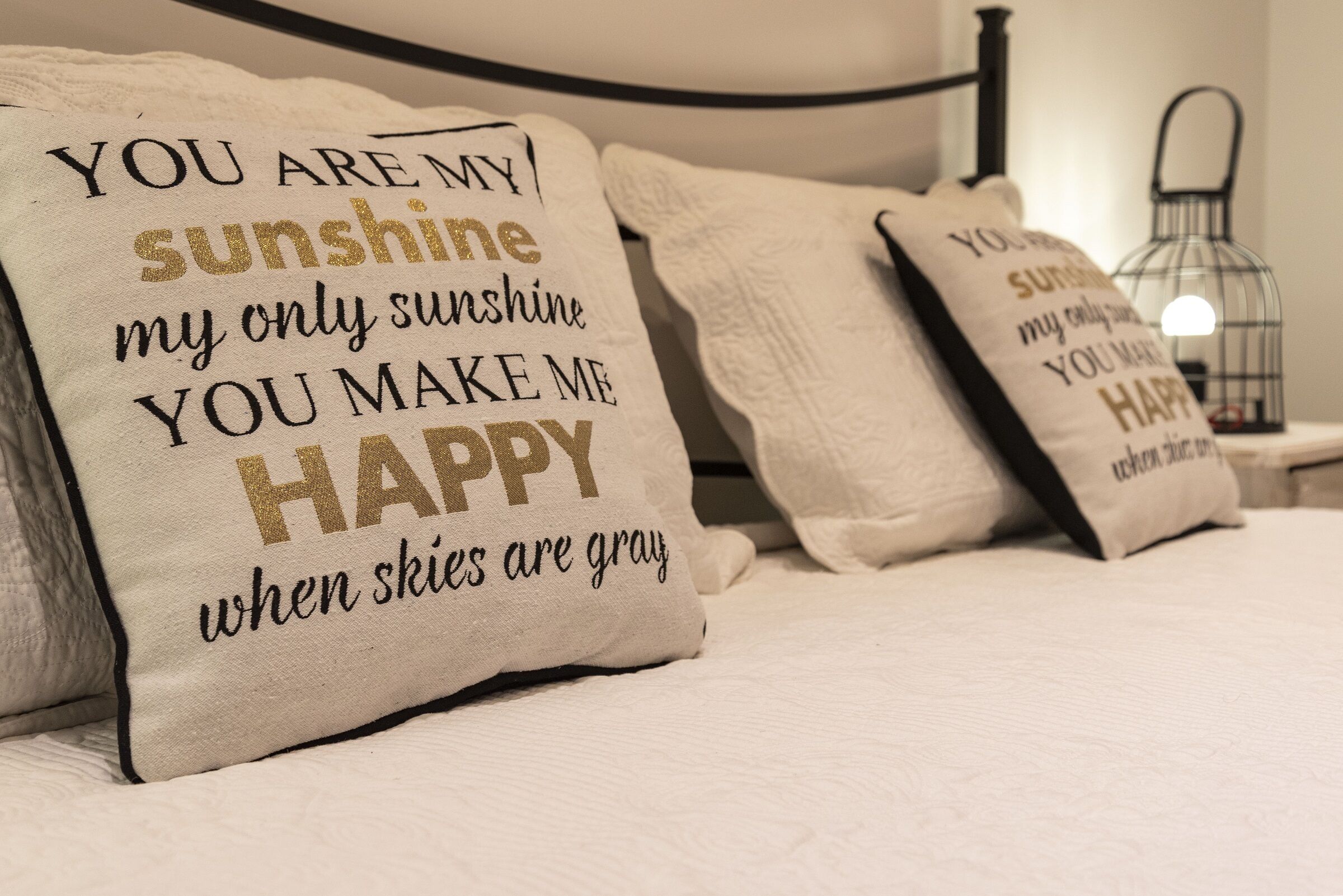 Una cama con almohadas decorativas que muestran citas inspiradoras.