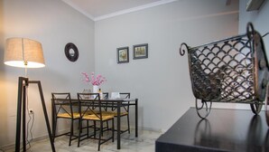 A dining area with a table and chairs, a floor lamp, and a decorative metal piece on a table.