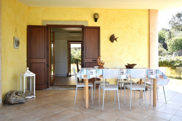 An open doorway leading to a room, a dining table with chairs, a lantern, and a decorative fish on the wall.