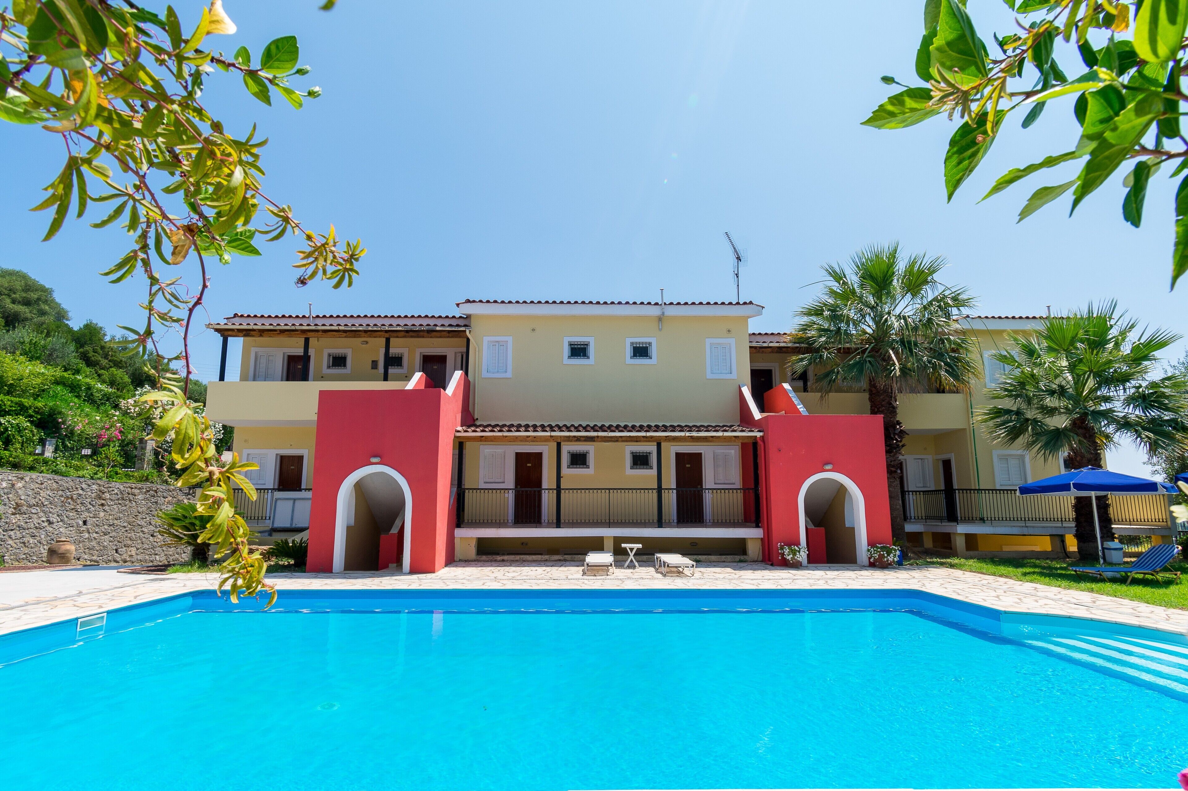 A two-story building with a swimming pool in front.