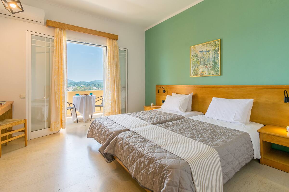 Habitación de hotel con cama, escritorio y vista al exterior.