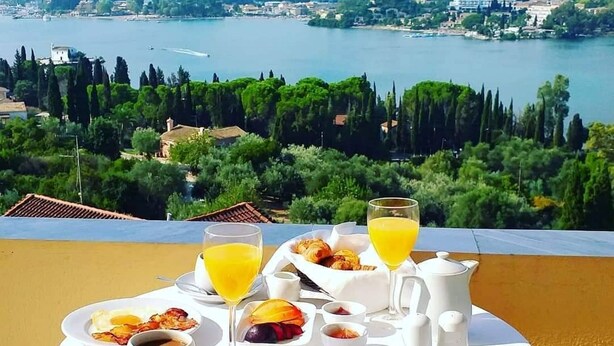 Una mesa de desayuno con vistas a un lago y colinas.