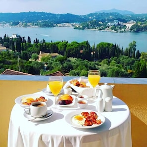 A breakfast table with a view of a lake and hills. - Elite Corfu - Adults Friendly (Corfu)